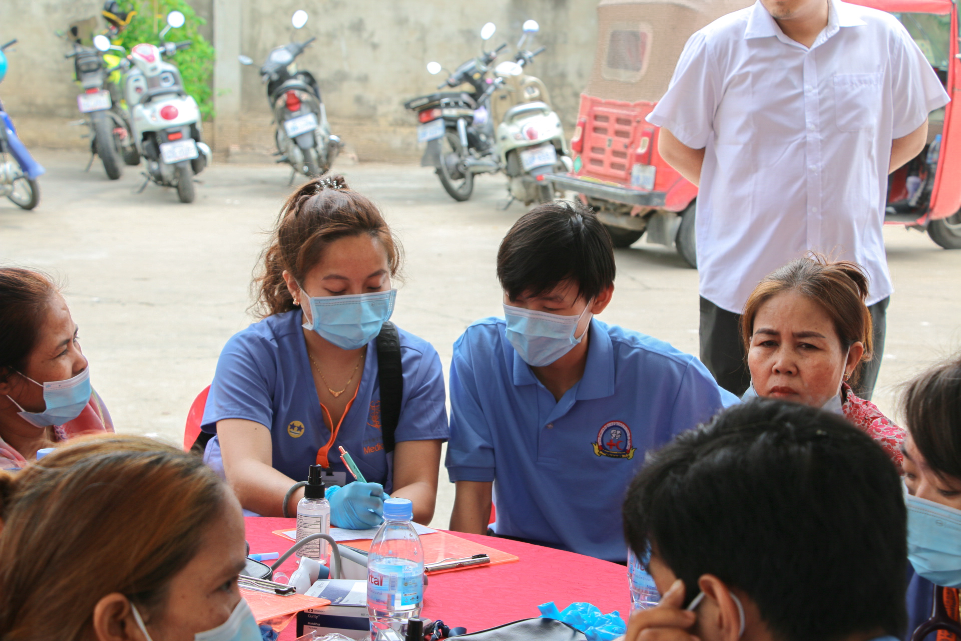 students in scrubs and masks sitting down at a table