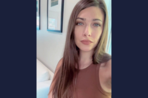 woman looks at camera with office in background